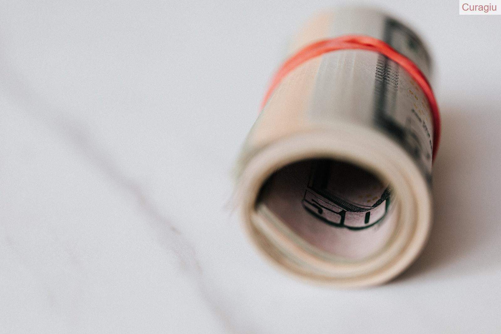 American dollar banknotes rolled and tightened with red band